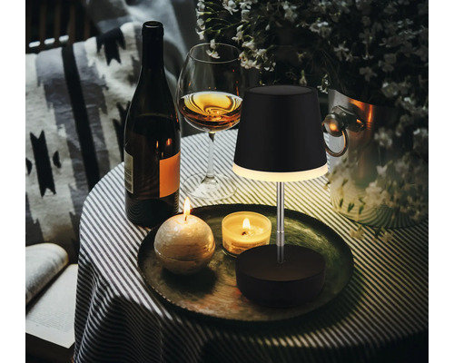 Szene mit Tischleuchte, Weinflasche, Weinglas und Kerzen