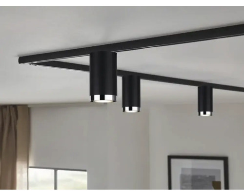 Schwarzes Schienensystem mit drei zylindrischen Strahlern an der Decke