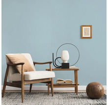 Wohnzimmer mit Sessel, Beistelltisch, Dekoration und Teppich