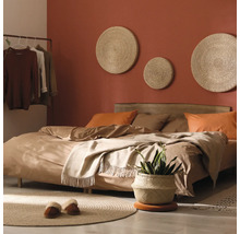 Schlafzimmer mit Bett, Wanddekorationen und Pflanzen