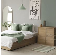 Schlafzimmer mit Bett, Nachttisch und Dekoration für ein gemütliches Ambiente