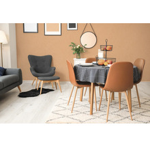 Helles Esszimmer mit Esstisch, Stühlen, Teppich und dekorativen Elementen.