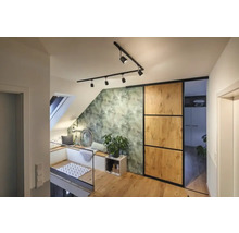 Helle Dachgeschosswohnung mit Dachfenster, Sitzecke, grüner Blättertapete, Schiebetür und Holzfußboden.