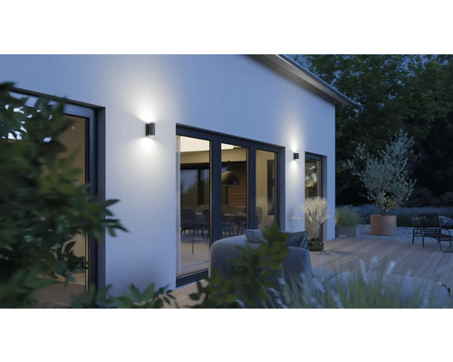 Außenansicht eines Hauses mit Garten und beleuchteten Wandleuchten