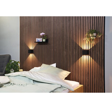 Schlafzimmer mit Akustikpaneelen an der Wand, Nachttischlampen und Dekoration