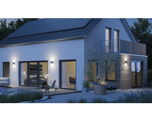 Modernes Haus mit Solarzellen auf dem Dach, Außenbeleuchtung und Gartenmöbeln