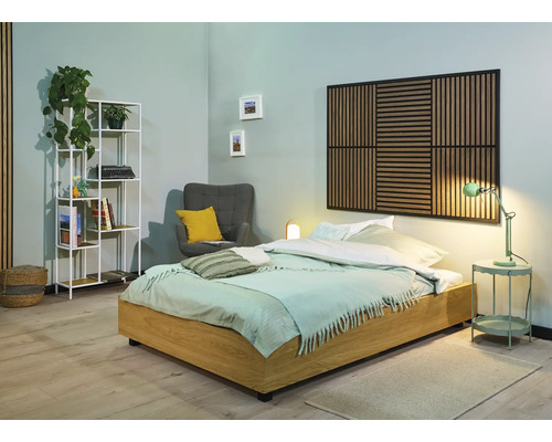 Schlafzimmer mit Bett, Nachttisch, Sessel, Regal und Wandpaneel