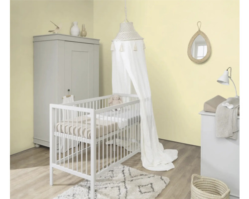 Helles Kinderzimmer mit Gitterbett, Baldachin, Wickelkommode, Kleiderschrank und Dekoration