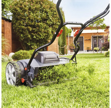 Rasenmäher in Aktion beim Rasenmähen im Garten.