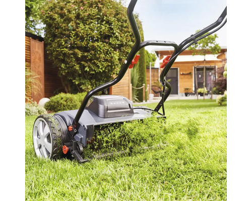 Rasenmäher in Aktion beim Rasenmähen im Garten.
