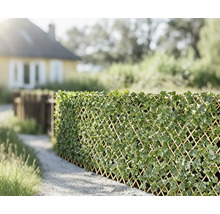 Dekorativer Sichtschutz aus Rankgitter mit künstlichen Blättern im Garten.