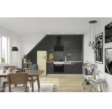 Helles Esszimmer mit Esstisch, Stühlen und Küchenzeile mit Elektrogeräten und Küchenschränken.