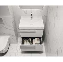 Modernes Badezimmer mit Waschbeckenunterschrank und geöffneter Schublade mit Badutensilien.