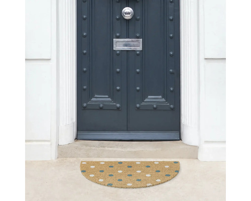 Halbrunde Fußmatte vor einer Haustür mit Punktmuster