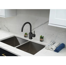 Küchenspüle mit Wasserhahn und dekorativen Elementen auf einer Arbeitsplatte.