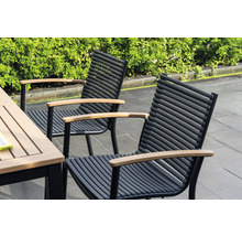 Zwei Gartenstühle mit Armlehnen aus Holz und schwarzen Metallrahmen stehen neben einem Gartentisch.