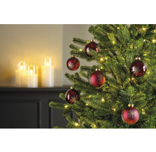 Dekorierter Weihnachtsbaum mit roten Weihnachtskugeln und Lichtern
