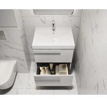 Modernes Badezimmer mit Waschbeckenunterschrank, geöffneter Schublade und Marmorfliesen