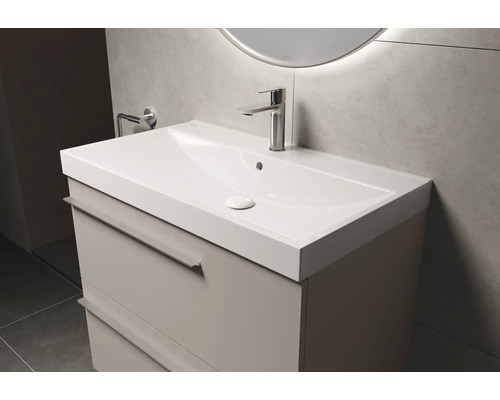 Waschtisch mit Unterschrank und Armatur im Badezimmer.
