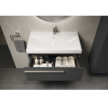 Waschtischunterschrank mit geöffneter Schublade, Waschbecken, Armatur, Handtüchern und Badutensilien im Badezimmer