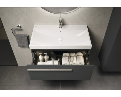 Waschtischunterschrank mit geöffneter Schublade, Waschbecken, Armatur, Handtüchern und Badutensilien im Badezimmer
