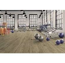 Fitnessstudio mit Sportgeräten und hellem Holzboden