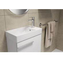 Badezimmerwaschtisch mit Armatur, Handtuchhalter und Handtuch.