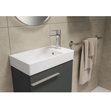 Badezimmer Waschbecken mit Unterschrank, Armatur und Handtuchhalter an der Wand