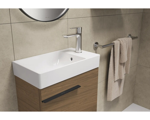 Waschbecken mit Unterschrank, Armatur und Handtuchhalter im Badezimmer