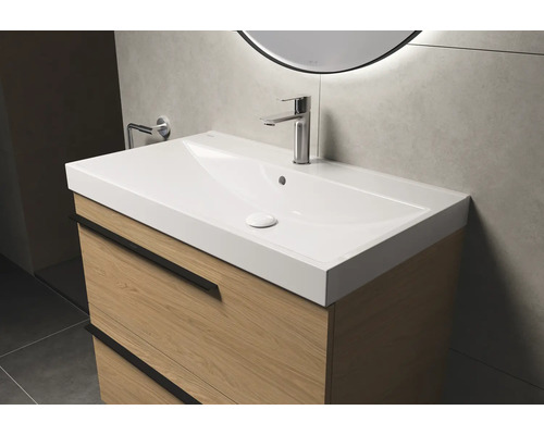 Waschtisch mit Unterschrank und Armatur im Badezimmer.
