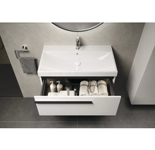 Waschtisch mit offenem Schubfach, Handtüchern und Pflegeprodukten im Badezimmer.