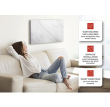 Frau entspannt auf Sofa unter Infrarotheizung mit Marmoroptik