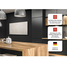 Wohnraum mit Natursteinheizung, Holztisch und Küchenzeile