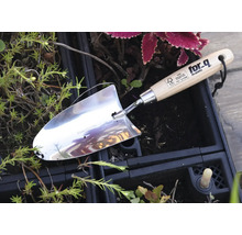 Edelstahllochschaufel mit Holzgriff im Gartenbeet