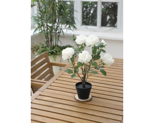 Dekorative Kunstrose im Topf auf einem Holztisch