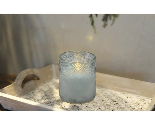 Kerze im Glas mit Muster auf einem Tablett