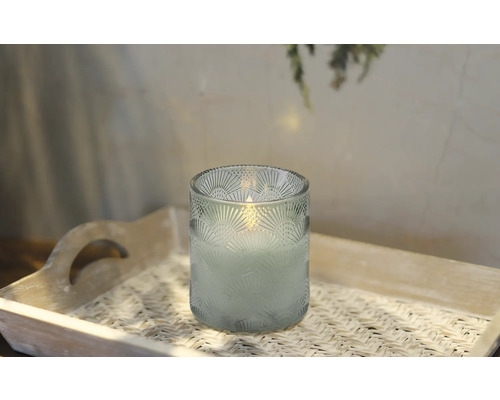 Dekorative Kerze in einem verzierten Glas auf einem Tablett