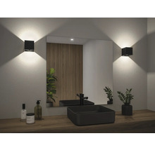 Modernes Badezimmer mit schwarzem Aufsatzwaschbecken, Spiegel, Wandleuchten und Holzverkleidung