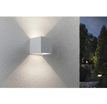 Quadratische Wandleuchte für den Außenbereich mit Lichtstrahlen an einer Fassade