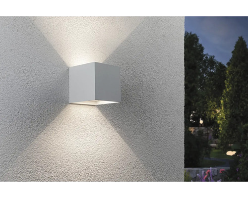 Quadratische Wandleuchte für den Außenbereich mit Lichtstrahlen an einer Fassade