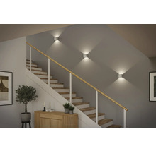 Treppenhaus mit Treppe, Treppengeländer und drei quadratischen Wandleuchten