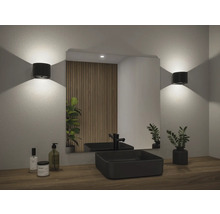 Badezimmer mit Spiegel, Waschbecken, Armatur und Wandleuchten