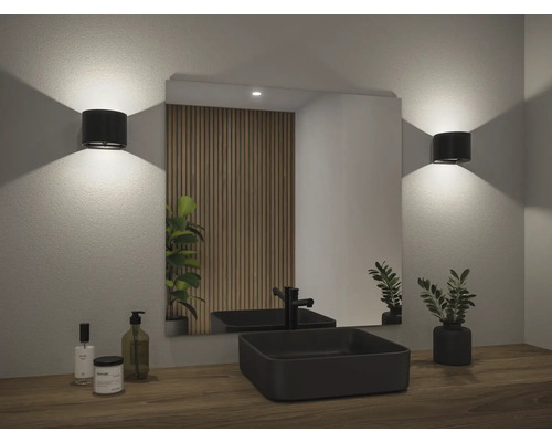 Badezimmer mit Spiegel, Waschbecken, Armatur und Wandleuchten