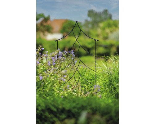 Gartenszene mit Rankhilfe in Tannenbaumform zwischen Pflanzen