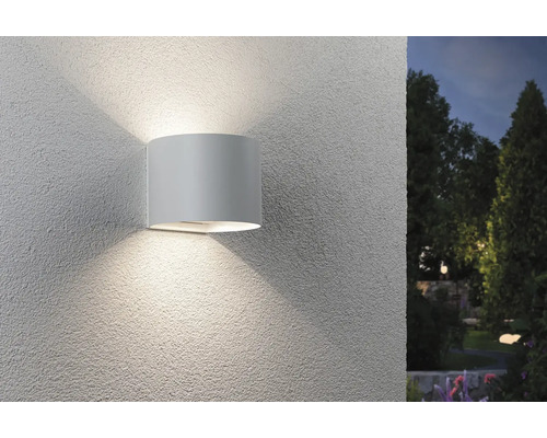 Mobile LED Wandleuchte Paulmann Nyora 3,2 W, mit Bewegungsmelder, weiß Eine zylindrische Wandleuchte strahlt Licht nach oben und unten an einer Wand ab.