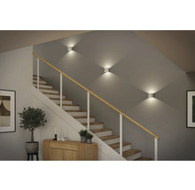 Treppenhaus mit Wandleuchten und Holztreppe