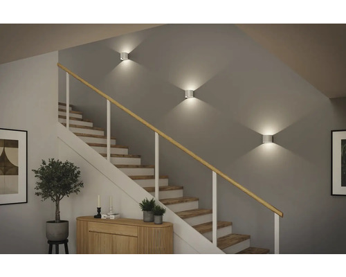 Treppenhaus mit Wandleuchten und Holztreppe