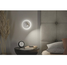 Schlafzimmerszene mit Nachttischlampe, Uhr und Buch