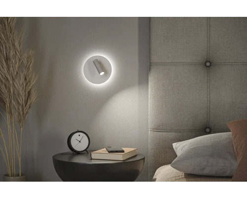 Schlafzimmerszene mit Nachttischlampe, Uhr und Buch