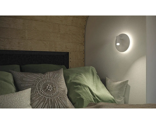 Schlafzimmer mit Wandleuchte, Kissen und Holzpaneelen